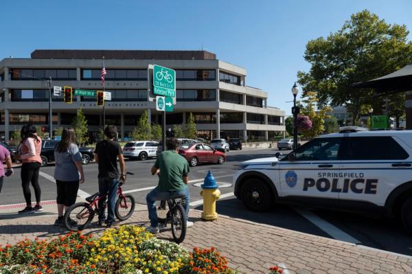 People watching Springfield Police Department officers investigating City Hall after bomb threats in Springfield, Ohio on September 12, 2024.