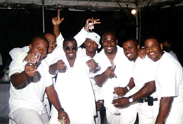 Music mogul Sean Combs, Reggie Osse, Navdeep Saini and group of men in all white clothing holding drinks at inaugural White Party in Hamptons