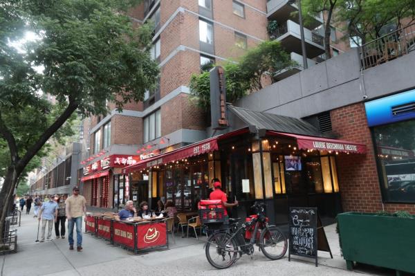 Front of West Bank Cafe with patrons dining outside.