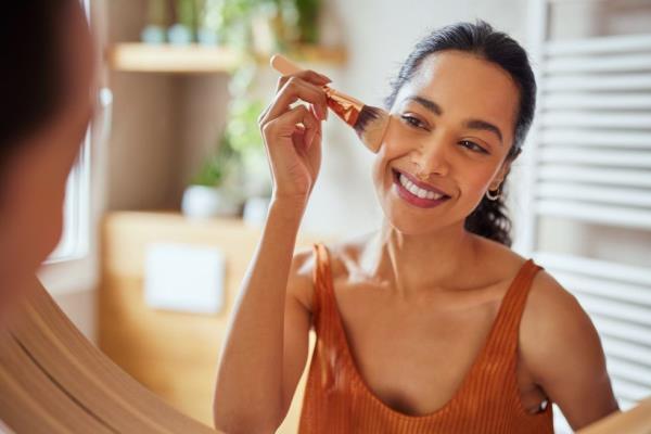 Woman applying makeup using powder brush